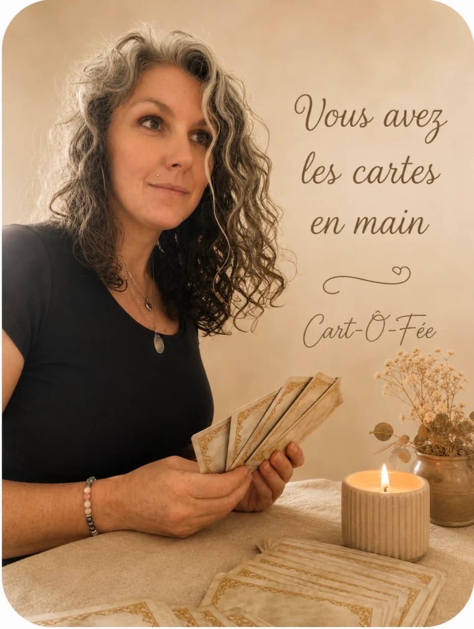Morgane, cartomancienne de Cart-Ô-Fée, tenant ses cartes à la lumière d’une bougie.